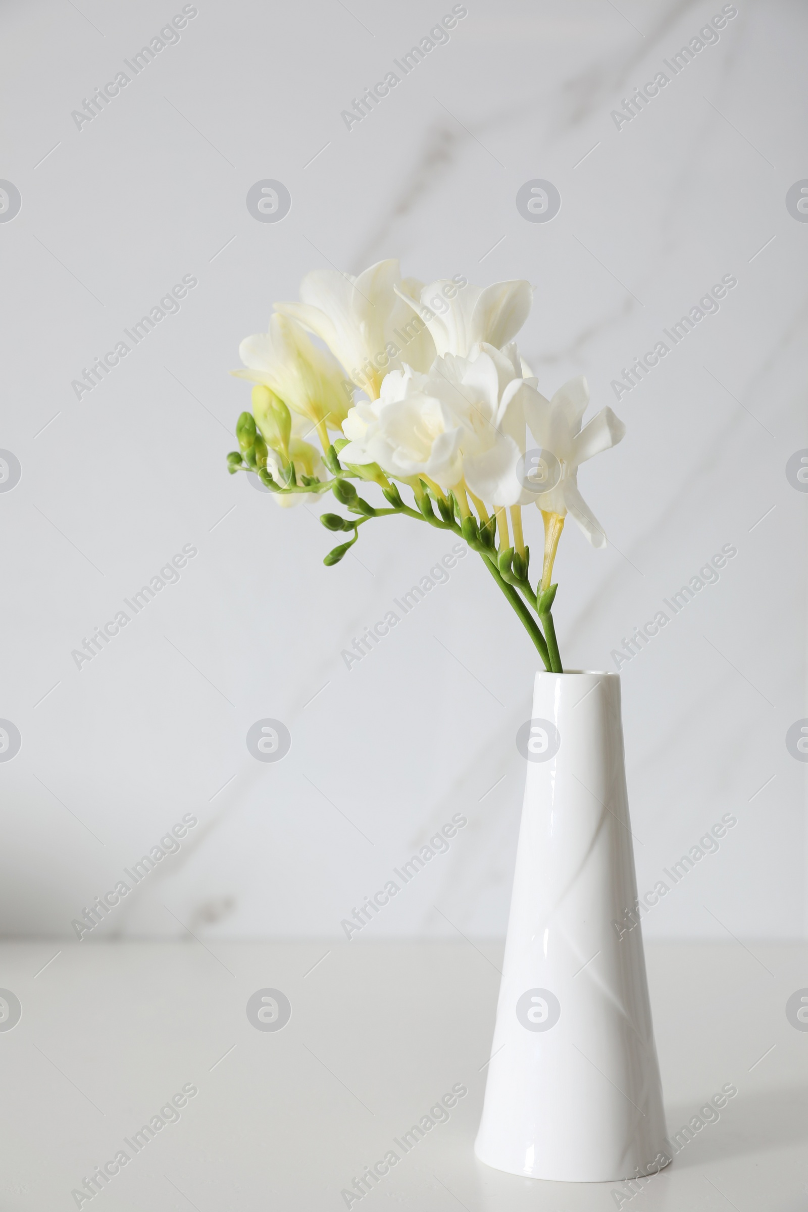 Photo of Beautiful bouquet with spring freesia flowers on white table