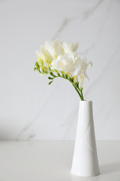 Beautiful bouquet with spring freesia flowers on white table