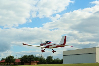 Photo of Modern ultralight airplane flying up from field