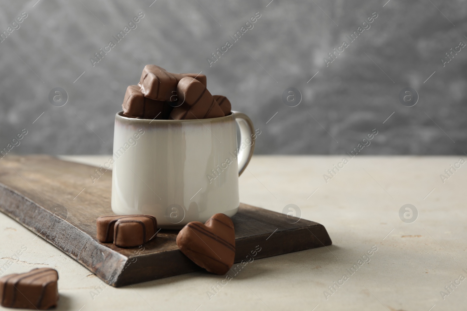 Photo of Delicious heart shaped chocolate candies on light table. Space for text