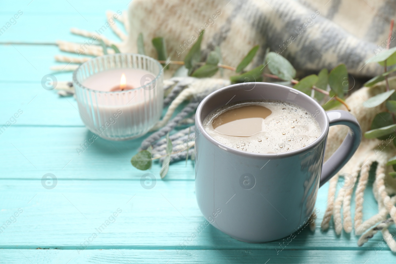 Photo of Composition with coffee and warm plaid on turquoise wooden table