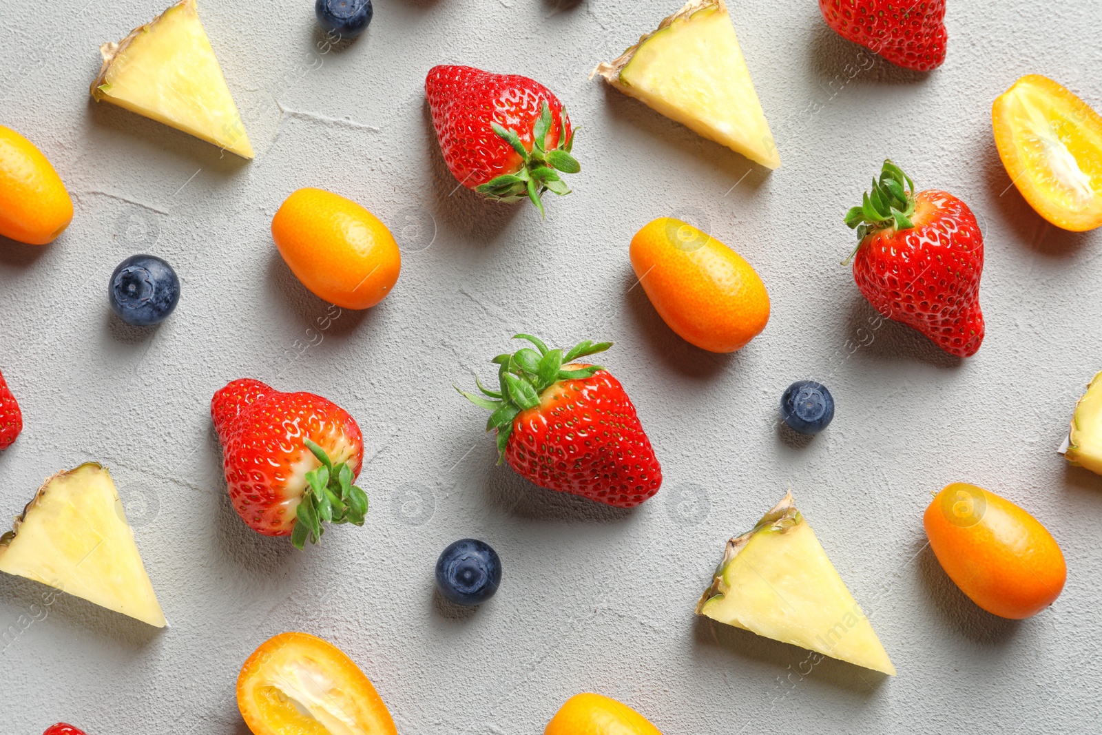 Photo of Flat lay composition with fresh berries and fruits on grey background