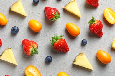 Flat lay composition with fresh berries and fruits on grey background