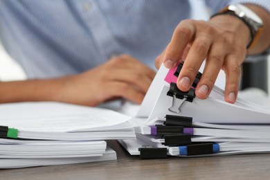 Photo of Man working with documents at wooden table in office, closeup