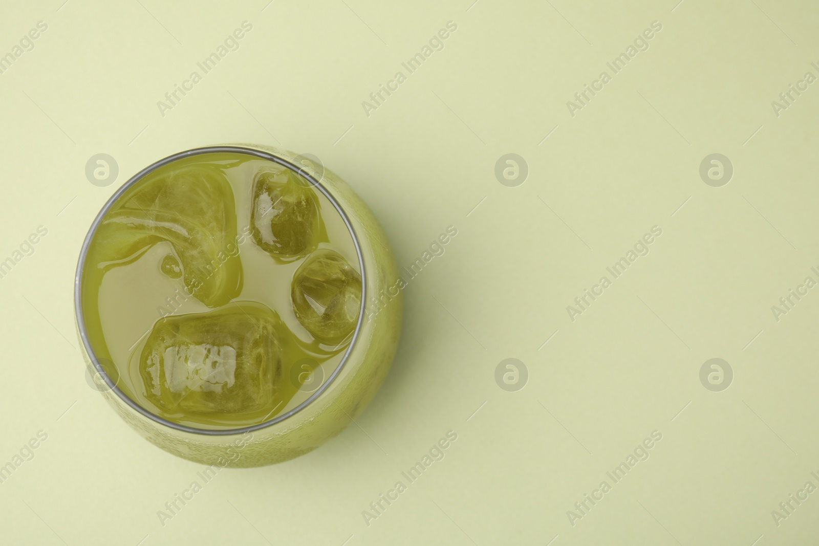 Photo of Glass of delicious iced matcha tea on green background, top view. Space for text