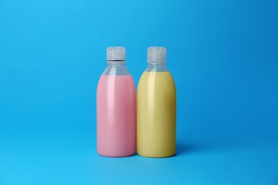 Bottles of detergents on light blue background. Cleaning supplies