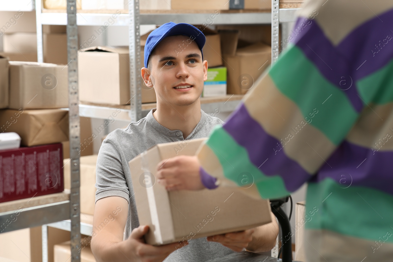 Photo of Worker giving parcel to woman at post office