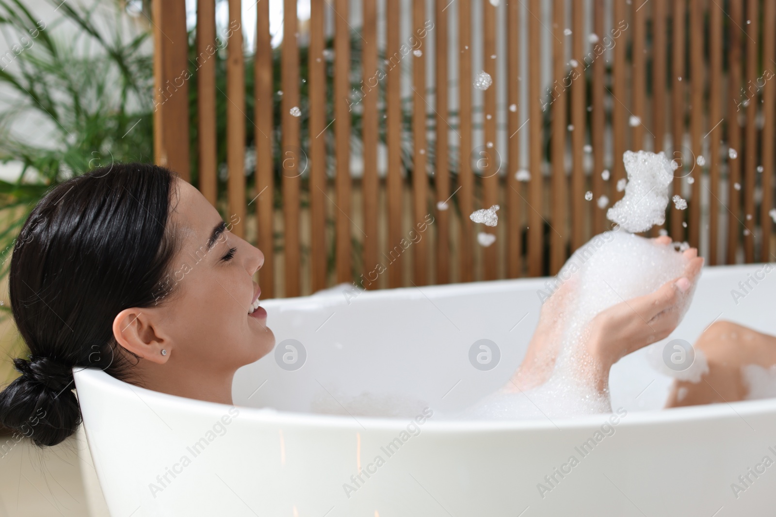 Photo of Beautiful young woman taking bubble bath at home