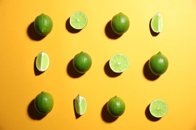 Photo of Flat lay composition with fresh juicy limes on yellow background