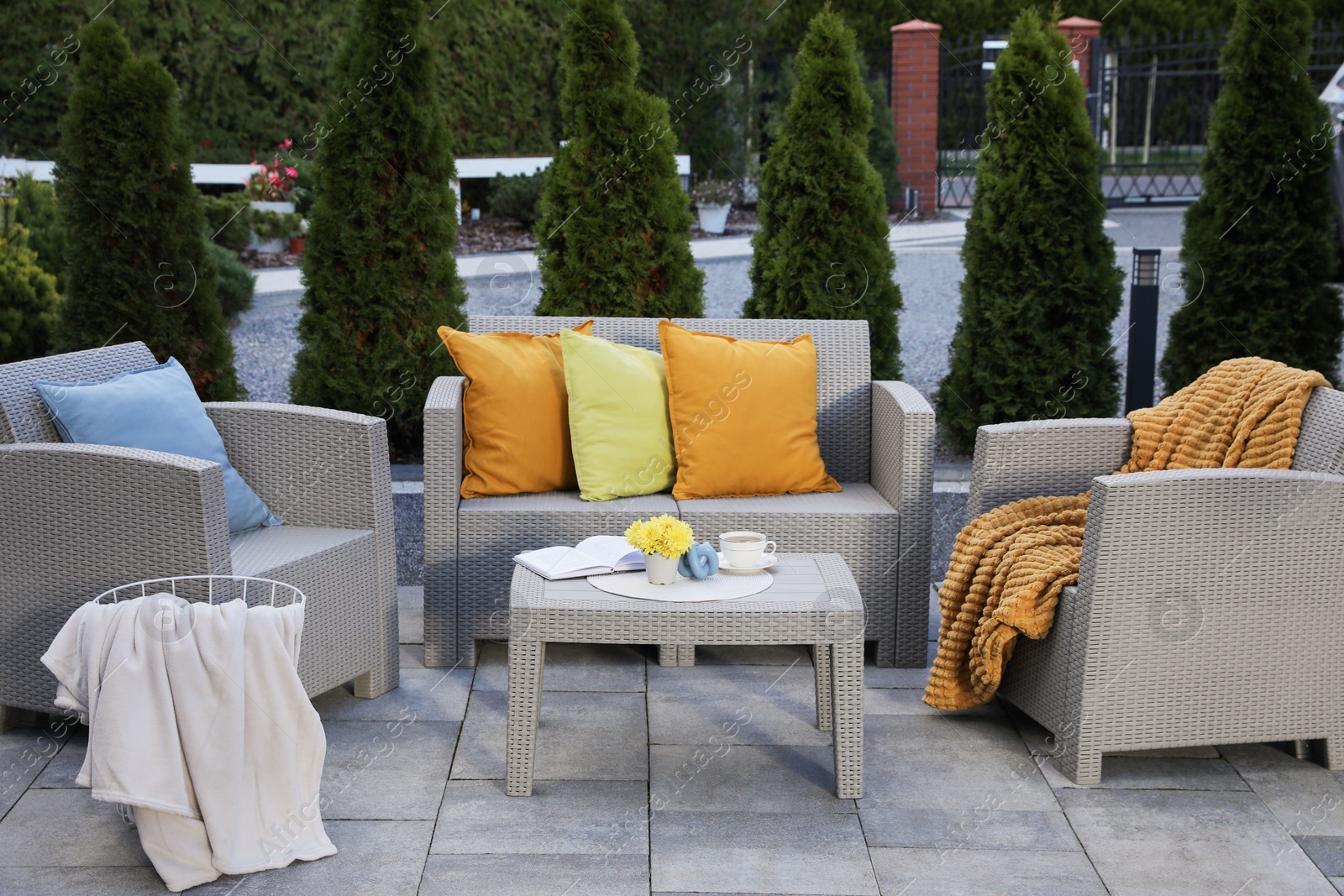 Photo of Beautiful rattan garden furniture, soft pillows and different decor elements outdoors