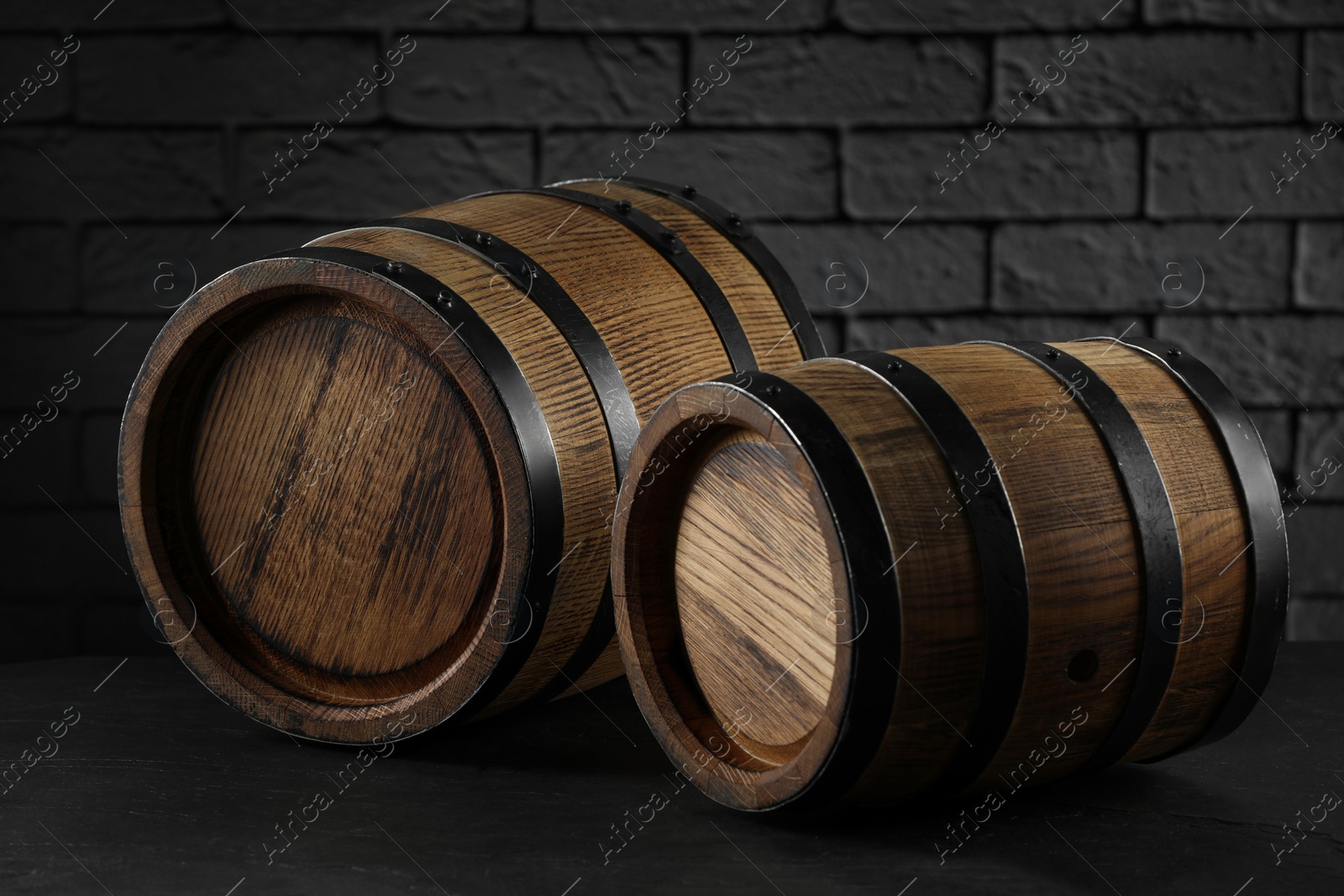 Photo of Wooden barrels on table near brick wall, closeup