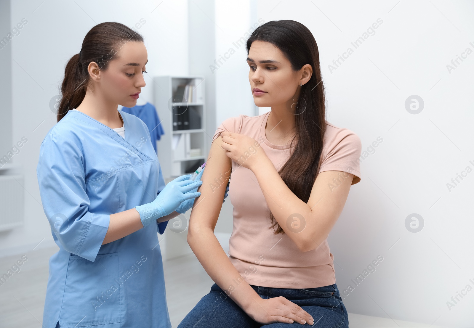 Photo of Doctor giving hepatitis vaccine to patient in clinic