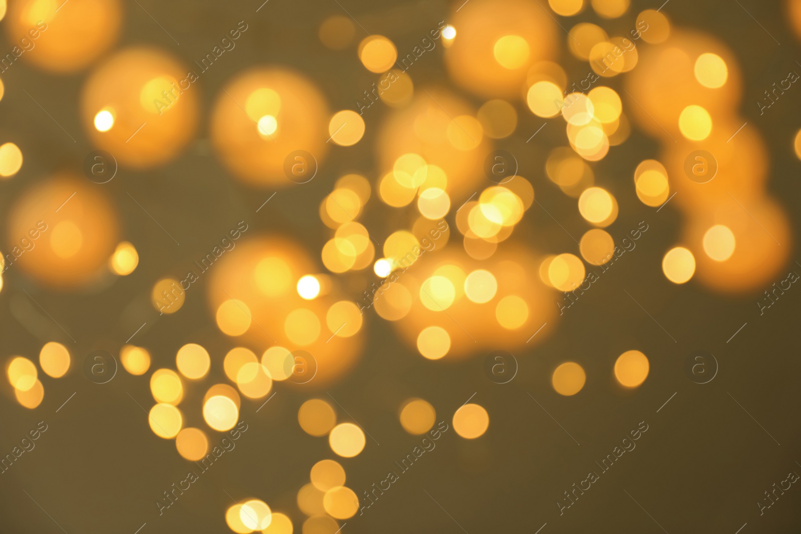 Photo of Blurred view of gold lights on dark background. Bokeh effect