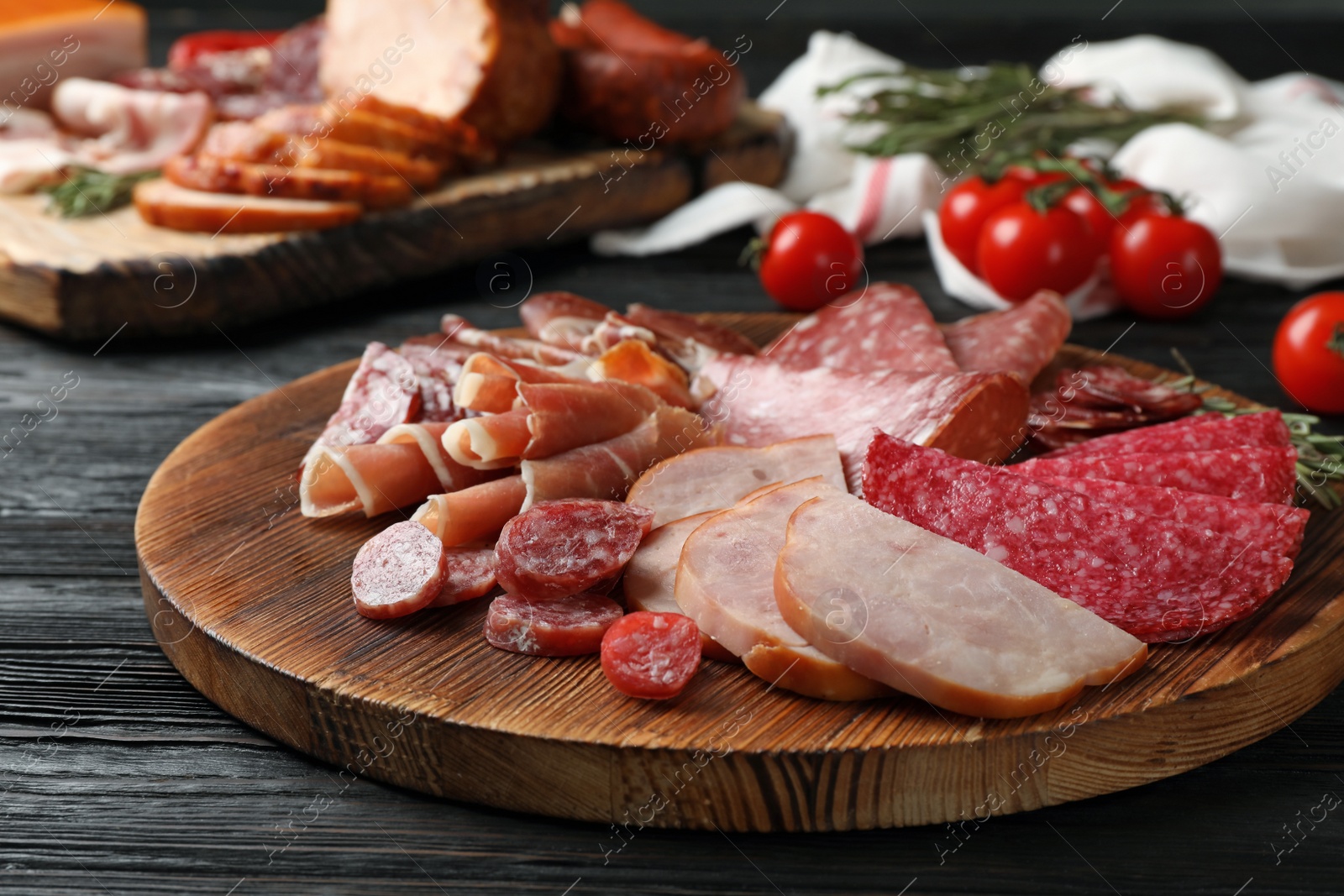 Photo of Cutting board with different sliced meat products served on table