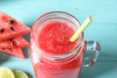 Tasty summer watermelon drink in mason jar on table, closeup