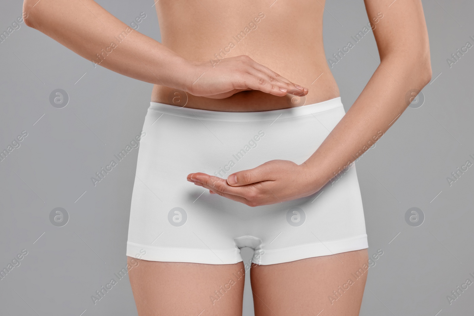 Photo of Woman holding something on grey background, closeup. Women's health