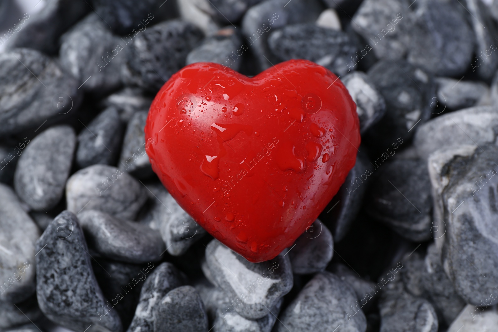 Photo of Red decorative heart on stones, closeup view