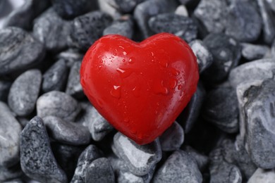 Red decorative heart on stones, closeup view