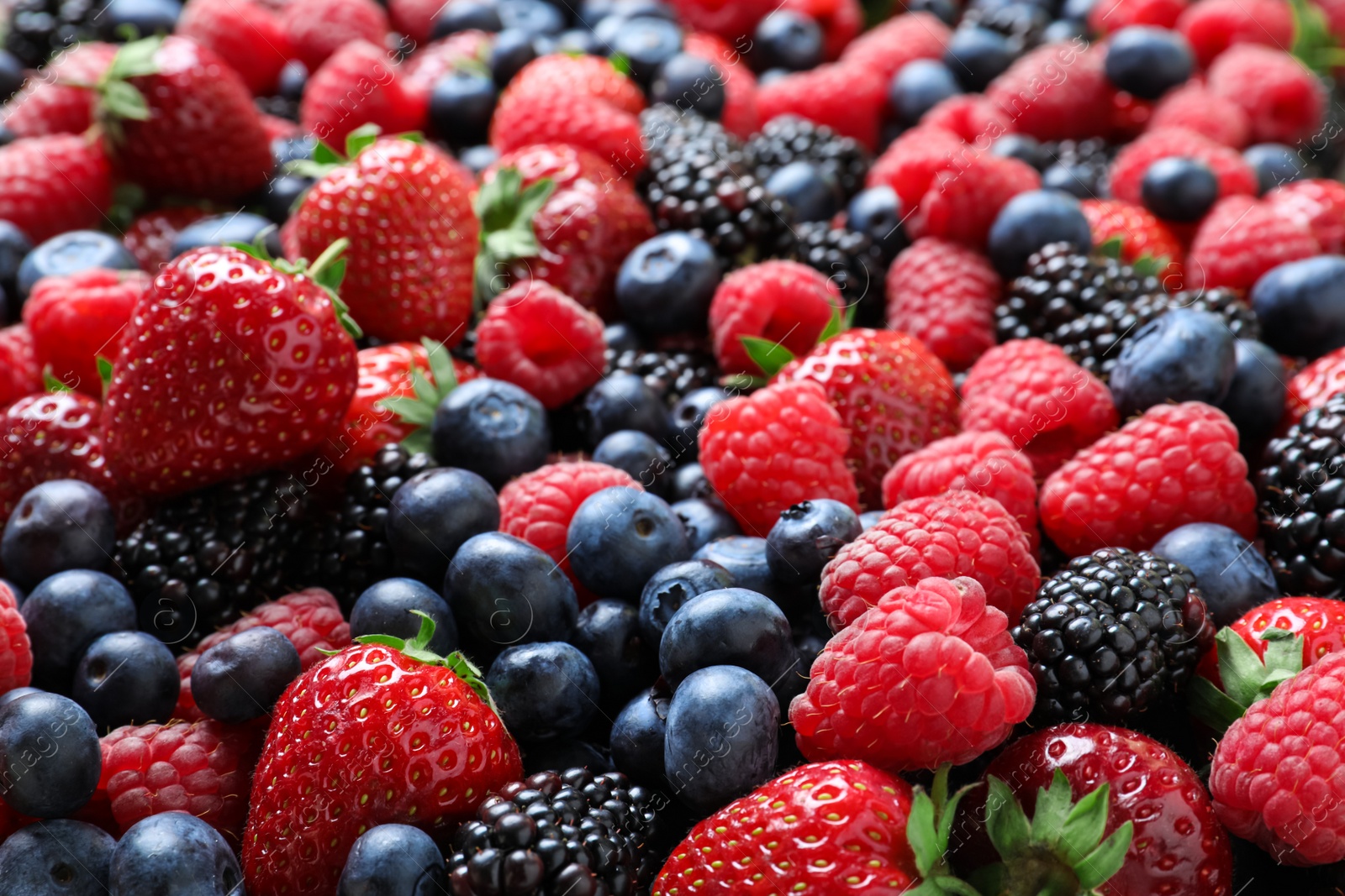 Photo of Mix of different ripe tasty berries as background, closeup view