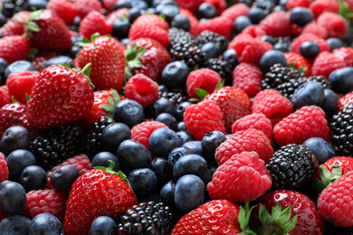 Photo of Mix of different ripe tasty berries as background, closeup view