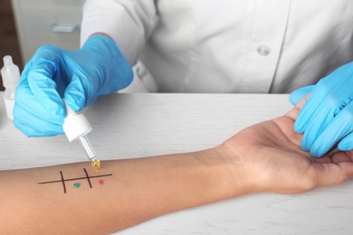 Doctor making allergy test at table, closeup