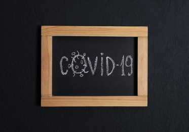 Blackboard with word Covid19 on black background, top view