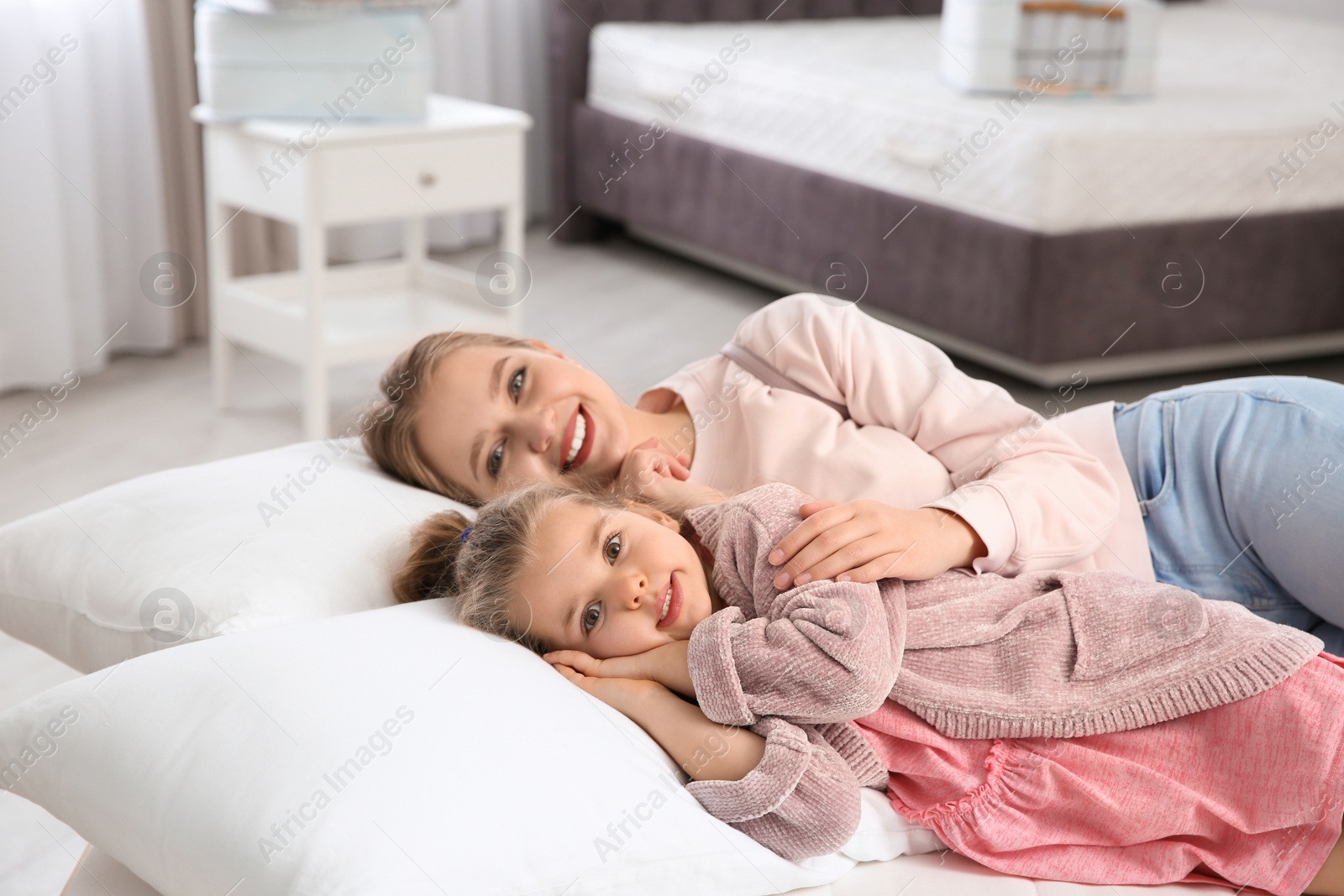 Photo of Mother and daughter testing mattress in store