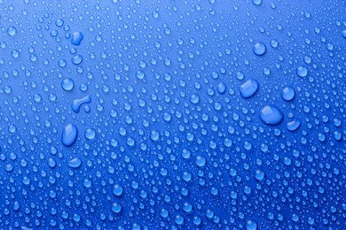 Photo of Water drops on blue background, top view