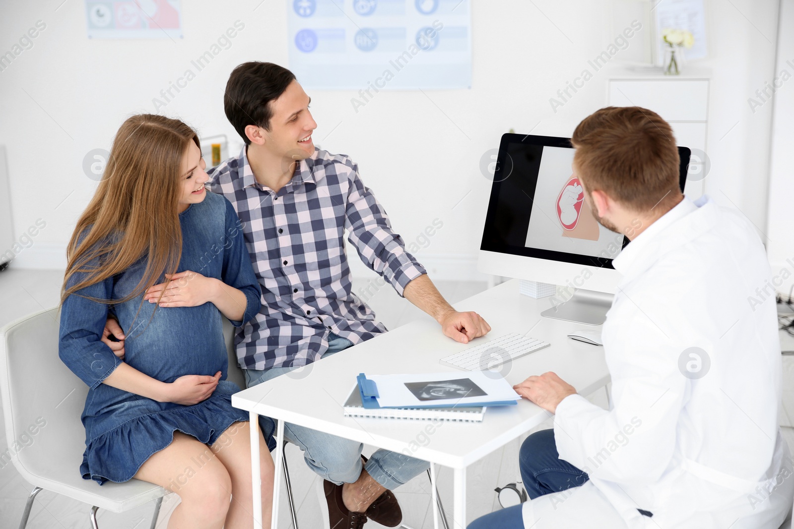 Photo of Gynecology consultation. Future parents with doctor in hospital