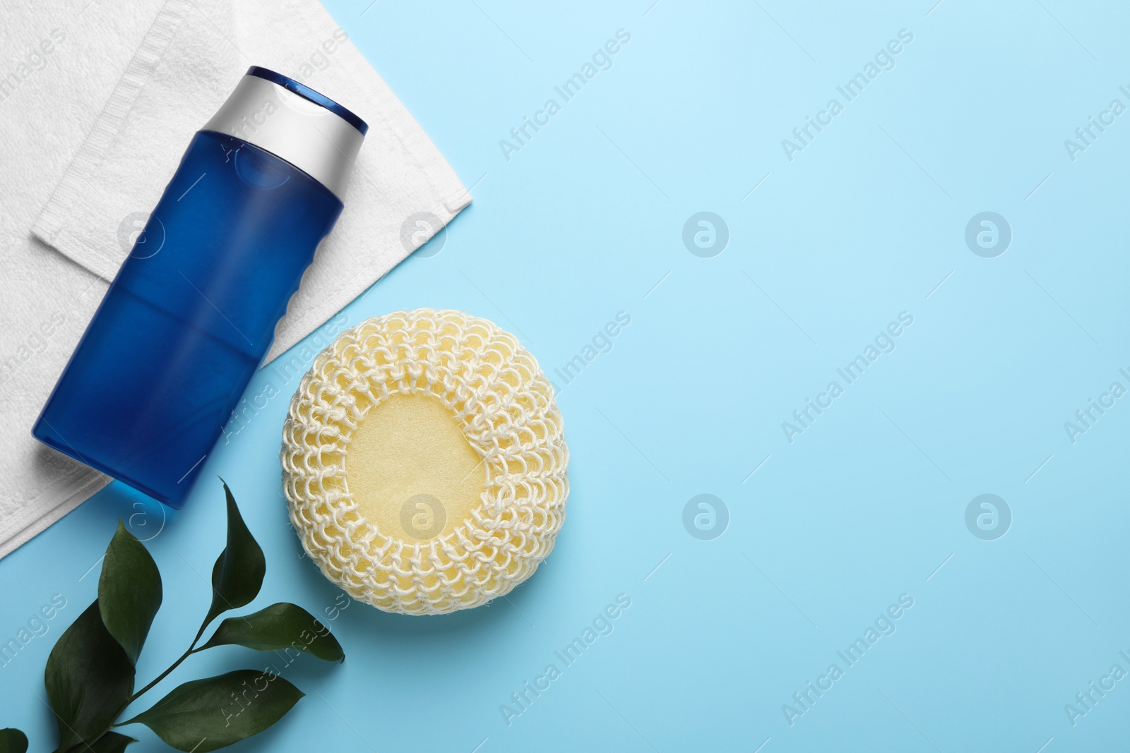 Photo of Flat lay composition with sponge and other bath supplies on light blue background. Space for text