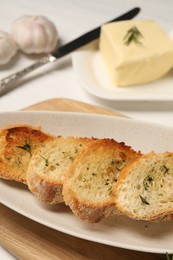 Photo of Tasty baguette with garlic and dill on table, closeup