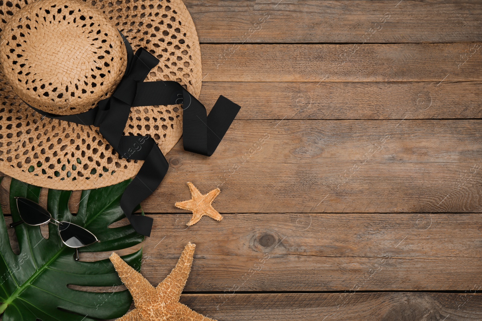 Photo of Flat lay composition with beach objects on wooden background, space for text