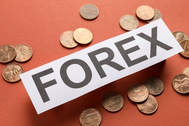 Photo of Sheet of paper with word Forex and coins on red background, closeup