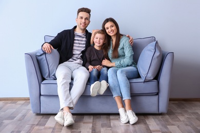 Photo of Happy family sitting on sofa, indoors