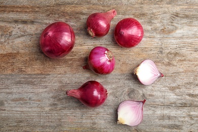 Photo of Flat lay composition with ripe red onions on wooden table