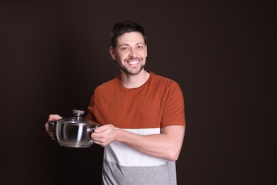 Photo of Happy man with pot on dark background