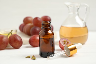 Photo of Natural grape seed oil on white wooden table. Organic cosmetic