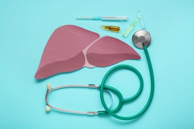 Paper liver, stethoscope, syringe and vials on turquoise background, flat lay. Hepatitis treatment