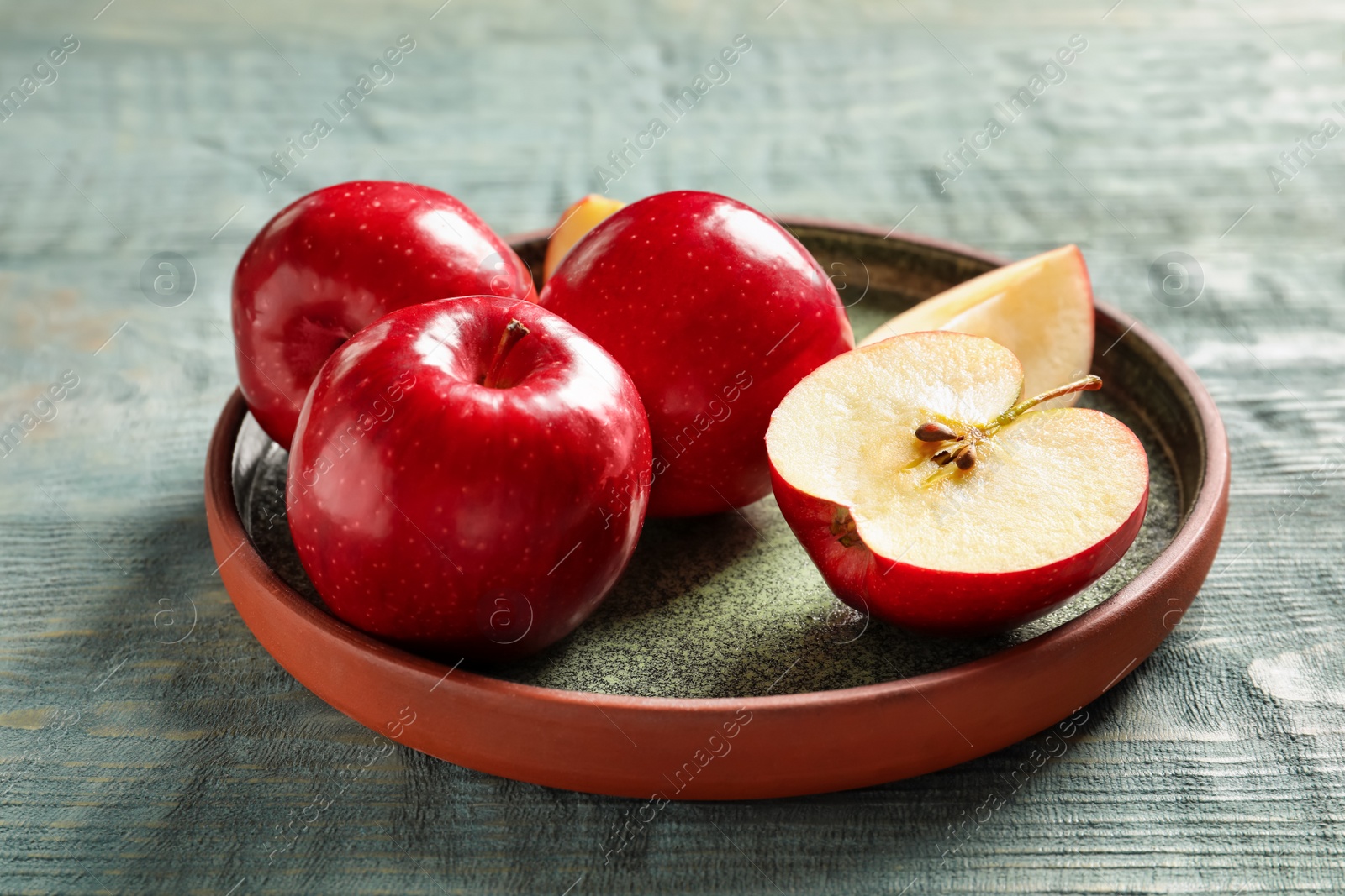 Photo of Plate with fresh ripe red apples on wooden background