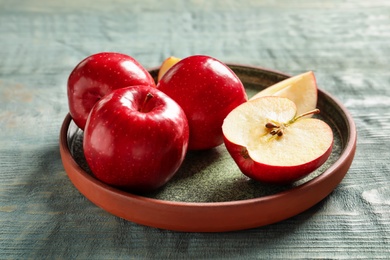 Photo of Plate with fresh ripe red apples on wooden background