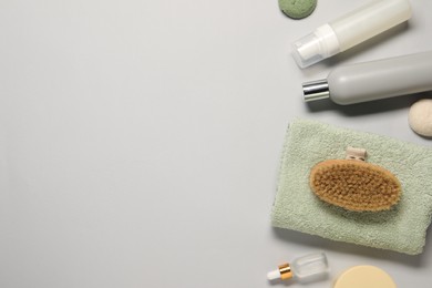 Bath accessories. Flat lay composition with personal care products on light grey background, space for text