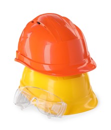 Hard hats and goggles isolated on white. Safety equipment