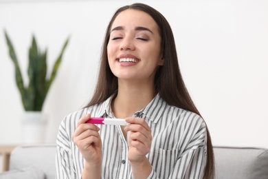 Photo of Young woman with pregnancy test at home. Gynecology and childbirth