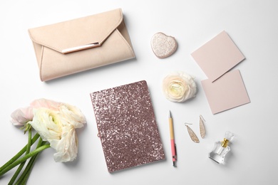 Flat lay composition with glittering notebook and spring flowers on white background