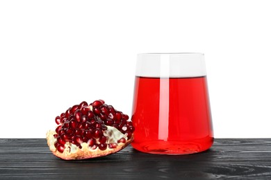 Photo of Refreshing pomegranate juice in glass and fruit on black wooden table against white background