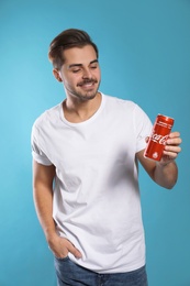 Photo of MYKOLAIV, UKRAINE - NOVEMBER 28, 2018: Young man with Coca-Cola can on color background