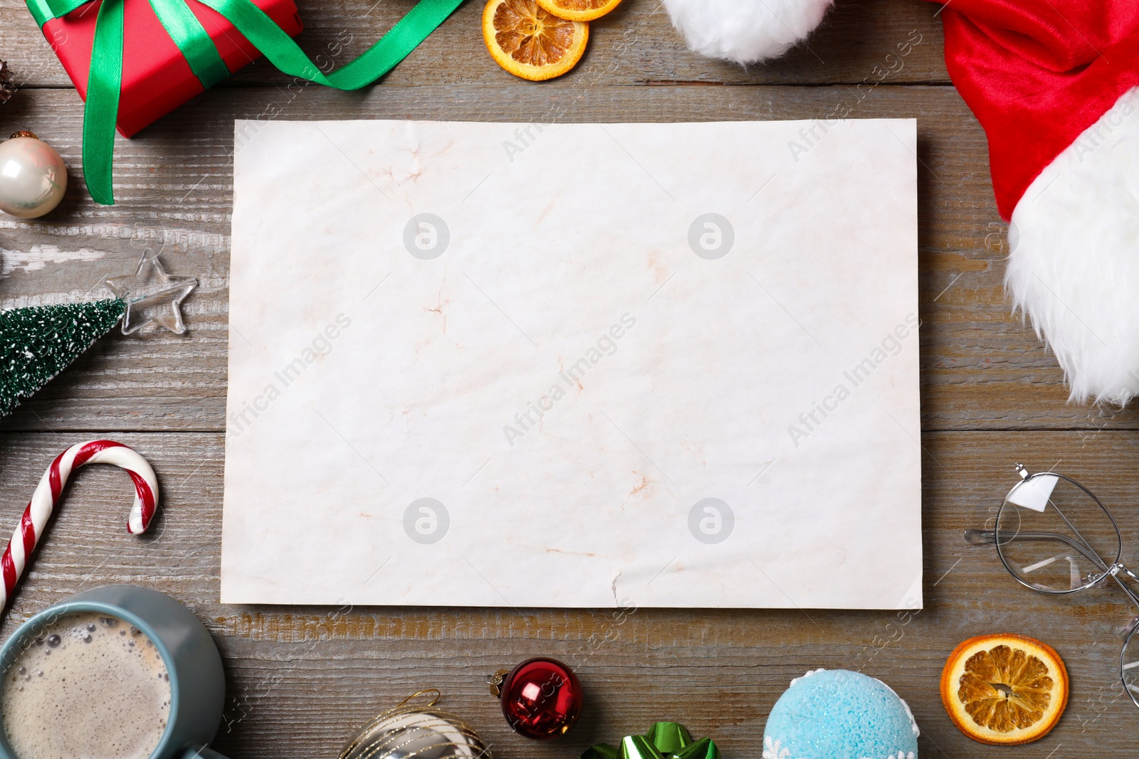 Photo of Flat lay composition with empty card and Christmas decorations on wooden table, space for text. Writing letter to Santa Claus