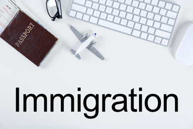 Flat lay composition with airplane model and computer keyboard on light background. Immigration concept