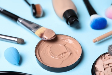 Photo of Composition with skin foundation and beauty accessories on color background