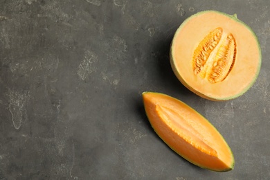 Photo of Tasty fresh cut melon on grey table, flat lay. Space for text